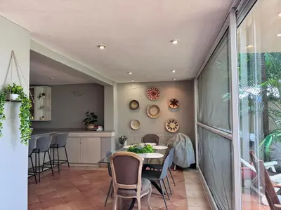 a dining room with a table and chairs at Olives by Agnes in Hartbeespoort