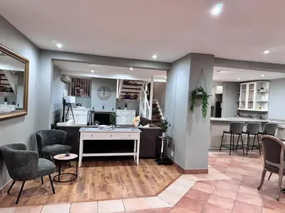 a living room with a table and chairs and a kitchen at Olives by Agnes in Hartbeespoort