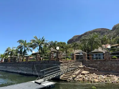 a boat is docked next to a building on the water at Olives by Agnes in Hartbeespoort