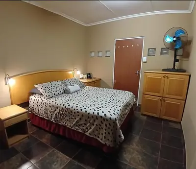 a bedroom with a bed and a table and a door at Prospectus Accommodation in Northam