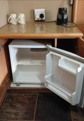 an open refrigerator sitting under a kitchen counter at Prospectus Accommodation in Northam