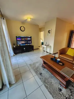 a living room with a couch and a table at 2d - 50 No load shedding - 2 bedroom in Centurion