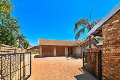 a brick house with a gate and a palm tree at Secured Home in Centurion