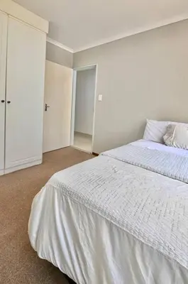 a white bedroom with a bed and a closet at Secured Home in Centurion
