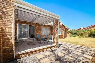 a patio with a table and chairs on a brick building at Secured Home in Centurion