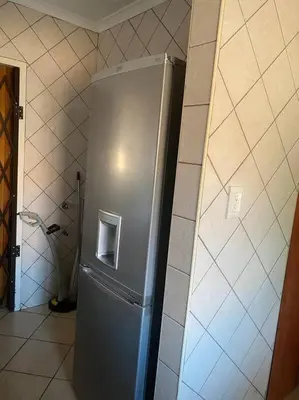 a stainless steel refrigerator in a corner of a room at Secured Home in Centurion