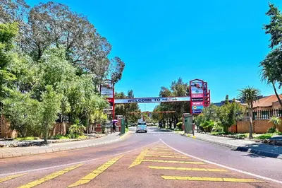 an empty street with a car driving down a road at Secured Home in Centurion