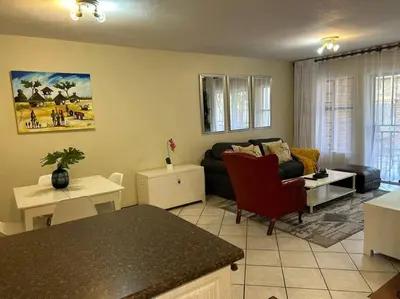 a living room with a couch and a table at 2c - 4 No load shedding 2bed 2bath with garden in Centurion