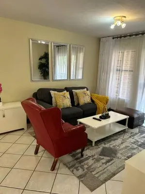 a living room with a couch and a table at 2c - 4 No load shedding 2bed 2bath with garden in Centurion