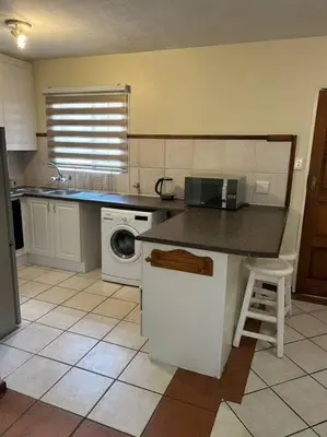 a kitchen with a counter and a washing machine at 2c - 4 No load shedding 2bed 2bath with garden in Centurion