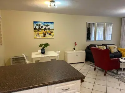 a kitchen and living room with a couch and a table at 2c - 4 No load shedding 2bed 2bath with garden in Centurion