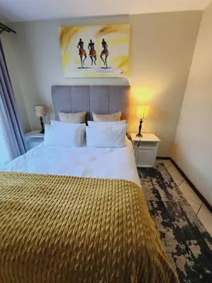 a bedroom with a bed and a painting on the wall at 2b - 74 No load shedding - 2 bed home in Centurion