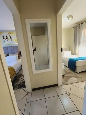 a room with two beds and a mirror at 2b - 74 No load shedding - 2 bed home in Centurion