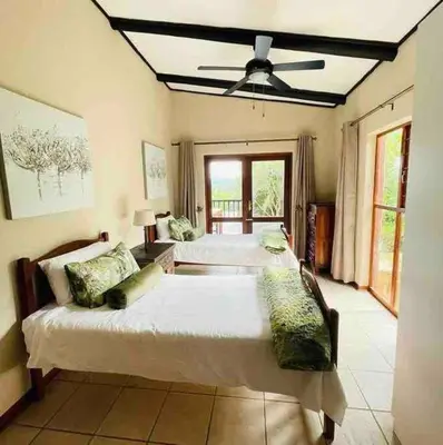 a large bedroom with two beds and a ceiling fan at Sycamore Fig House next 2 Hulala Lodge in White River