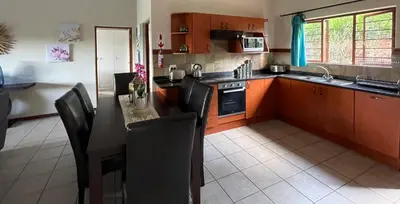 a kitchen with a table and chairs in a kitchen at Sycamore Fig House next 2 Hulala Lodge in White River