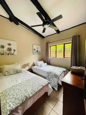 a bedroom with two beds and a ceiling fan at Sycamore Fig House next 2 Hulala Lodge in White River
