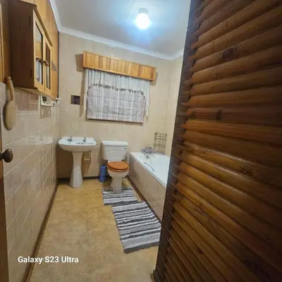 a bathroom with a toilet and a sink and a tub at Yello guest house chalets in Graskop