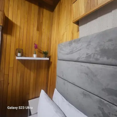 a room with a wooden wall with a bench at Yello guest house chalets in Graskop
