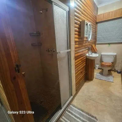 a bathroom with a shower and a toilet at Yello guest house chalets in Graskop