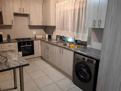 a kitchen with a sink and a dishwasher at Azrisi Apartments in Kempton Park