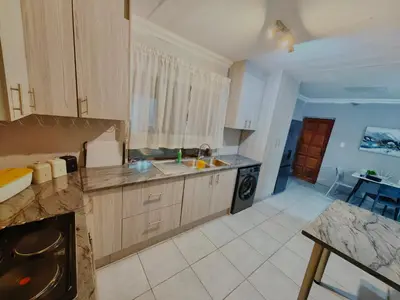 a kitchen with a sink and a stove at Azrisi Apartments in Kempton Park