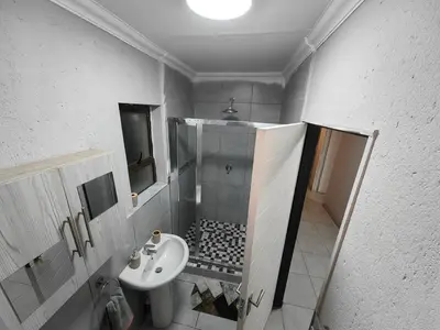 a small bathroom with a sink and a toilet at Azrisi Apartments in Kempton Park