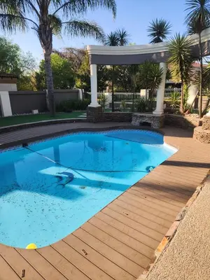 a pool with a wooden deck and a gazebo at Blue Valley Golf Estate in Centurion