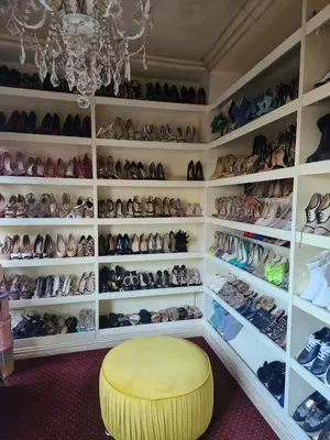 a room filled with shelves filled with shoes and a yellow stool at Blue Valley Golf Estate in Centurion