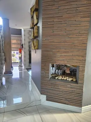 a living room with a fireplace in the wall at Blue Valley Golf Estate in Centurion
