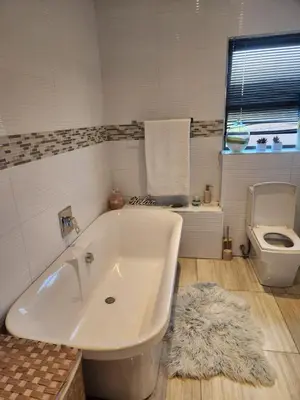 a bathroom with a tub and a toilet and a rug at Blue Valley Golf Estate in Centurion