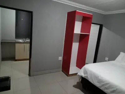 a bedroom with a bed and a red and white wall at Elangeni Guest House in Mahubahuba