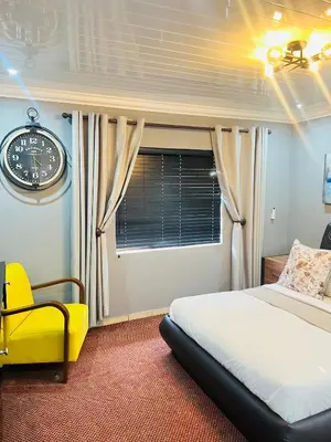 a bedroom with a bed and a clock on the wall at 9 on Burger Blue Waters in Polokwane