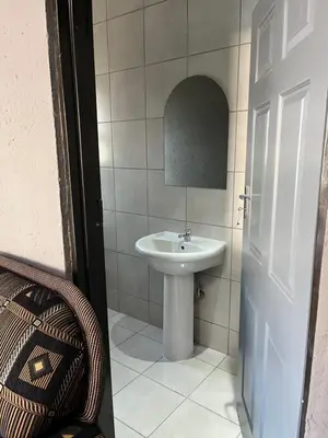 a bathroom with a white sink and a toilet at Família BnB in Tekwane