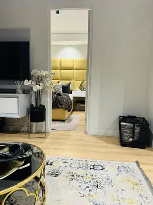 a living room with a couch and a television at Homely - 1 bedroom rental unit at Ellipse in Midrand