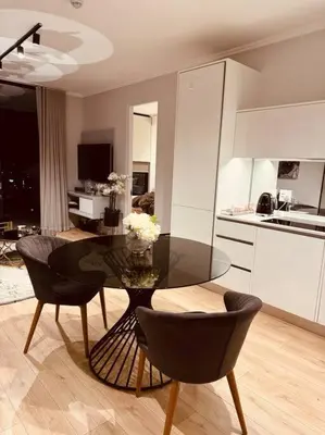 a kitchen with a glass table and chairs in a room at Homely - 1 bedroom rental unit at Ellipse in Midrand