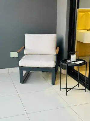 a white chair and a side table in a room at Homely - 1 bedroom rental unit at Ellipse in Midrand