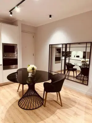 a dining room with a glass table and chairs at Homely - 1 bedroom rental unit at Ellipse in Midrand