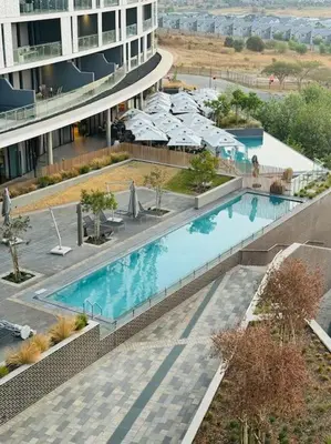 an overhead view of a swimming pool in a building at Homely - 1 bedroom rental unit at Ellipse in Midrand