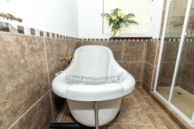 a bath tub in a bathroom with a sink at Bolivia Lodge in Polokwane