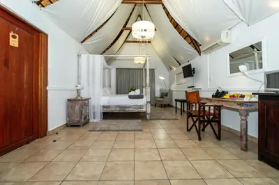 a living room with a bed and a table at Bolivia Lodge in Polokwane