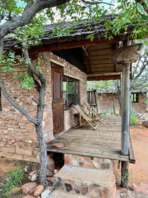 a brick building with a wooden porch and a door at Kaoxa Bush Camp in Alldays