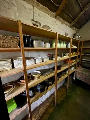 a kitchen with wooden shelves filled with pots and pans at Kaoxa Bush Camp in Alldays