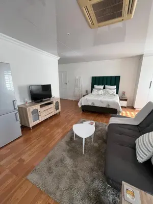 a living room with a couch and a bed at Charming Urban Retreat in Centurion