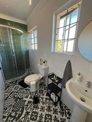 a bathroom with a toilet and a shower and a sink at Charming Urban Retreat in Centurion