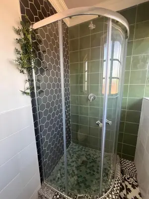 a shower with a glass door in a bathroom at Charming Urban Retreat in Centurion