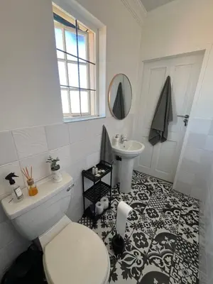 a bathroom with a toilet and a sink at Charming Urban Retreat in Centurion