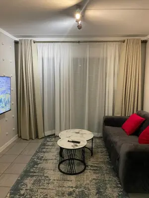 a living room with a couch and a table at Tranquil 2 bed 2 bath studio in Sandton