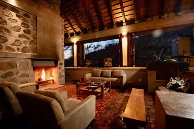 a living room with couches and a fireplace at The Riverine Lodge in Welgevonden Game Reserve