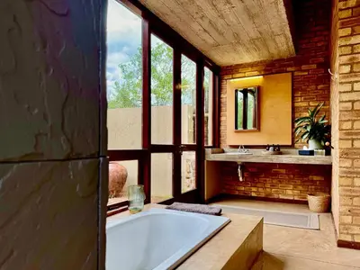a large bathroom with a tub and a sink at The Riverine Lodge in Welgevonden Game Reserve
