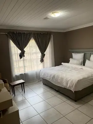 a bedroom with a large bed and a window at Home Sweet Home Farmhouse in Nelspruit